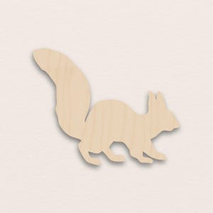 Op de afbeelding: Houten uitgesneden eekhoorn in een natuurlijke houttint. De eekhoorn is afgebeeld in een zijaanzicht, met een grote, volle staart en gedetailleerde kenmerken. Ideaal voor knutselwerkjes en doe-het-zelf projecten.
