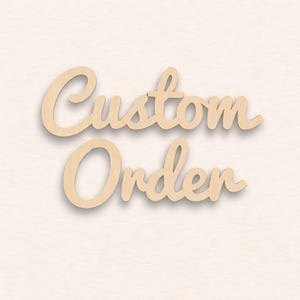 May include: Wooden cutout sign with the words "Custom Order" in a cursive font. The sign is made of light-colored wood and is set against a soft, off-white background. The letters have a slight shadow effect.