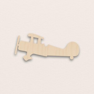 以下が含まれることがあります： プロペラ、翼、尾を持つ木製の複葉機カットアウト。 飛行機は明るい色の木でできており、シンプルで二次元のデザインです。 複葉機は、クラシックなおもちゃまたは装飾品です。
