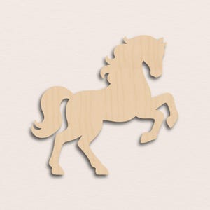 Puede incluir: Recorte de madera de un caballo en posición encabritada. El caballo es de color marrón claro con un acabado liso, y la crin y la cola son fluidas. El recorte está diseñado para ser un elemento decorativo, adecuado para manualidades o decoración del hogar.