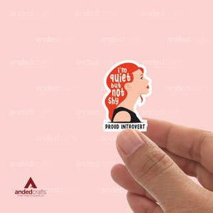 May include: A sticker with a red-haired woman's silhouette and the text "I'm quiet but not shy. Proud Introvert".