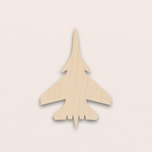 Può includere: Sagoma in legno di un jet da combattimento, di colore marrone chiaro. Il jet ha ali, un muso appuntito e una coda. Il design è semplice e pulito, con un focus sulla silhouette dell'aereo.