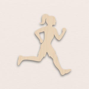 Puede incluir: Silueta de madera de una persona corriendo, con coleta y pantalones cortos. La figura está en plena carrera, con los brazos y las piernas extendidos. El recorte es de madera clara sobre un fondo neutro.