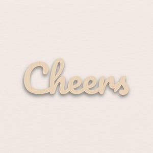 Könnte beinhalten: Holzschild mit dem Wort "Cheers" in Schreibschrift. Das Schild ist aus hellem Holz gefertigt und vor einem neutralen Hintergrund platziert. Ideal für die Inneneinrichtung.
