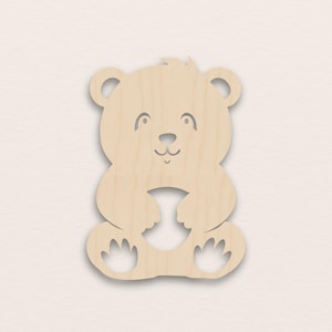 Könnte beinhalten: Holzausschnitt eines Teddybären mit lächelndem Gesicht, Ohren und Pfoten. Der Bär ist hellbraun und hat eine glatte Oberfläche. Das Design ist einfach und eignet sich für Bastelarbeiten oder Dekorationen.