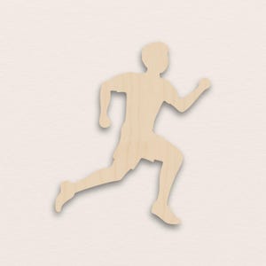 Puede incluir: Silueta de madera de una persona corriendo, vista de perfil. La figura lleva pantalones cortos y una camiseta de manga corta. El recorte es de madera clara y está sobre un fondo neutro.