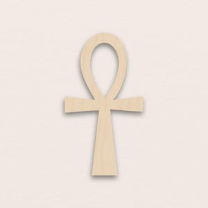 May include: A light-colored wooden ankh symbol, a cross with a loop at the top. The ankh is a symbol of life and immortality in ancient Egyptian culture. The ankh is a light tan color and is set against a neutral background.
