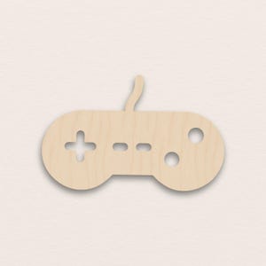 May include: A light-colored wooden video game controller cutout. The controller features a directional pad, two buttons, and two circular holes. The design is simple and modern, perfect for gaming enthusiasts.