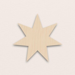 May include: A wooden starburst shape with eight points. The star is made of light-coloured wood, possibly birch or maple, and has a natural wood grain pattern. The star is centered on a cream-coloured background.