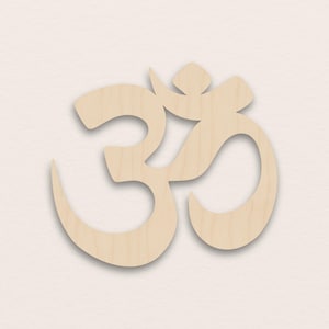 Könnte beinhalten: Ein hellfarbenes Om-Symbol aus Holz, eine spirituelle Ikone im Hinduismus, Buddhismus und Jainismus. Das Symbol ist aus hellfarbenem Holz geschnitten und hat eine glatte Oberfläche. Das Design zeigt eine geschwungene Form mit einer zentralen vertikalen Linie und einer halbmondförmigen Spitze.
