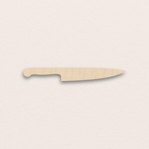 May include: A wooden chef's knife with a light brown finish. The knife features a curved handle and a sharp, pointed blade. The knife is designed for kitchen use.