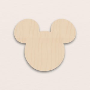 May include: A wooden cutout in the shape of a cartoon mouse head, with a large circular head and two rounded ears. The wood has a light, natural colour and a smooth surface, suitable for crafting or decoration.