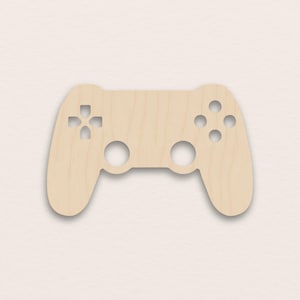 Könnte beinhalten: Aus Holz gefertigte Aussparung eines Videospiel-Controllers. Der Controller ist hellbraun und hat ein kreuzförmiges Steuerkreuz, vier runde Knöpfe und zwei Löcher für Analog-Sticks. Ein klassisches Gaming-Zubehör.