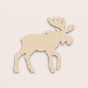 Op de afbeelding: Een houten eland uitgesneden in een lichtbruine kleur. De eland wordt afgebeeld in een wandelhouding, met gedetailleerde geweien en een klein gaatje om op te hangen. De uitgesneden vorm is gemaakt van glad, onafgewerkt hout.
