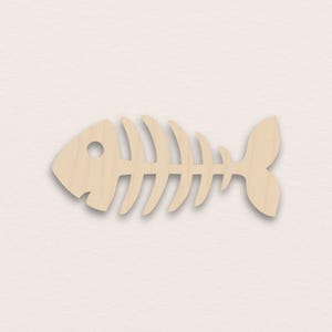Puede incluir: Recorte de madera clara con forma de esqueleto de pez. El esqueleto de pez tiene una cabeza con un ojo circular, una serie de costillas curvas y una aleta caudal. El recorte está hecho de madera clara y se encuentra sobre un fondo neutro.