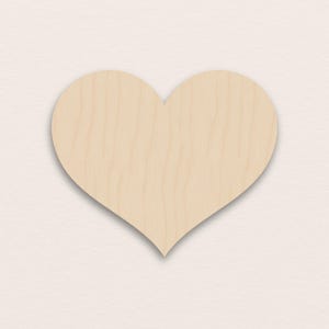Könnte beinhalten: Ein herzförmiger Holzzuschnitt mit natürlicher Holzmaserung. Das Herz hat eine hellbeige Farbe und eine glatte Oberfläche. Der Ausschnitt ist eine einfache, aber elegante Form, perfekt für Bastelarbeiten und Dekorationen.