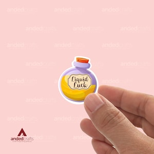 Könnte beinhalten: Eine violette Glasflasche mit einer gelben Flüssigkeit. Die Flasche hat ein Etikett mit der Aufschrift "Liquid Luck".