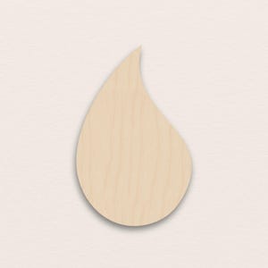Może przedstawiać: Wycięcie z drewna w kształcie łzy, w jasnobrązowym kolorze i z widocznym usłojeniem drewna. Wycięcie ma gładką, zaokrągloną podstawę i spiczastą górę. Prawdopodobnie przeznaczone do celów rzemieślniczych lub dekoracyjnych.