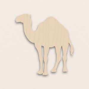 May include: A wooden cutout of a camel in a standing position. The camel is light brown with visible wood grain. The cutout is a silhouette with detailed legs, a hump, and a head facing left. The background is a light beige.