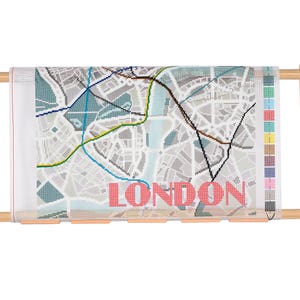 May include: A wooden embroidery hoop with a white canvas featuring a map of London with colourful lines and the word "LONDON" printed in pink.
