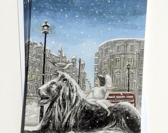 May include: A snowy winter scene with a white angel riding a black lion statue. The angel is wearing a white robe and has wings. The lion is sitting on a snow-covered street with a red double-decker bus in the background. The scene is lit by a street lamp.