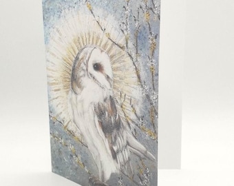 May include: A white barn owl with a halo of light, perched on a branch with delicate white blossoms. The background is a soft blue with hints of gold.