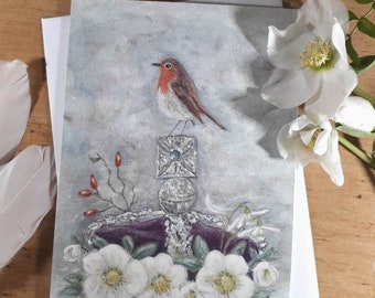 May include: A watercolor painting of a robin perched on a crown of white flowers. The crown is surrounded by green leaves and red berries. The background is a soft blue.