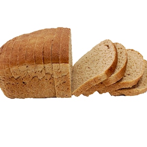 May include: A loaf of sliced brown bread. The bread is partially sliced and the slices are stacked on top of each other.