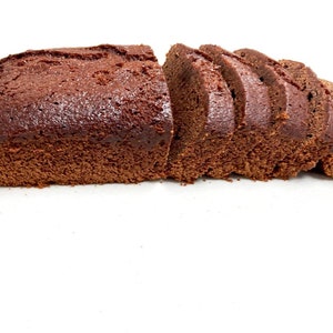 May include: A loaf of chocolate cake sliced into pieces on a white surface.