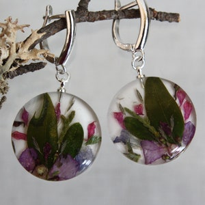 Disc earrings with pressed flowers in resin. Bright flower on a white background. Terrarium earrings. Botanical jewelry.