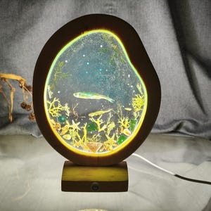 Lampada da notte in resina epossidica, con motivo a veri pesci marini, in legno massello.