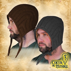Puede incluir: Se muestran dos capuchas medievales, una marrón y otra gris oscuro. Presentan un diseño acolchado y lazos largos. El logotipo "Coeur de Mithril" es visible. Estas capuchas son adecuadas para recreaciones históricas o disfraces.