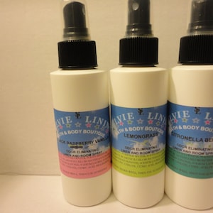 May include: Three clear spray bottles with black tops and labels. The labels are blue and white with pink, green, and yellow stars. The bottles are labeled "Black Raspberry Vanilla", "Lemongrass", and "Citronella Berry". Each bottle says "Odor Eliminating Linen and Room Spray".
