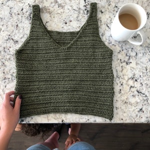May include: A green crochet tank top with a V-neck and thin straps.