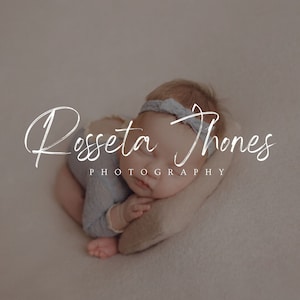 May include: A sleeping baby wearing a light blue onesie and a light gray headband. The baby is lying on a light brown pillow. The text "Rosseta Jones Photography" is written in white cursive script above the baby.