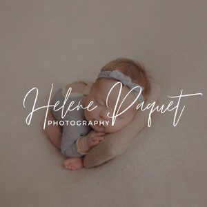 May include: A newborn baby wearing a blue outfit and headband, sleeping on a small pillow. The image has the text "Helene Paquet PHOTOGRAPHY" in a cursive font.