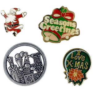 May include: A collection of Christmas-themed pins. Includes a Santa Claus pin, a pin with the text "Seasons Greetings" and bells, a silver train pin, and a green pin with the text "I Love X-MAS" and a poinsettia.