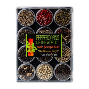 May include: A rectangular clear plastic container holding twelve circular compartments filled with various types of peppercorns. A central black label features the text PEPPERCORNS OF THE WORLD, exotic flavorful heat!, The Spice of Kings!, and Salts of the 7 Seas.