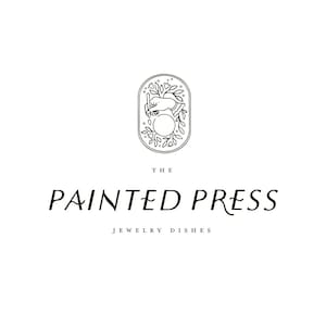 May include: The Painted Press logo features a black and white illustration of a hand holding a circle surrounded by leaves inside an oval. The text below reads "The Painted Press Jewelry Dishes".