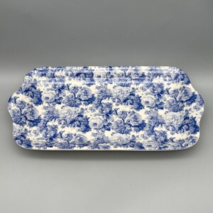 May include: A rectangular serving tray with rounded corners and integrated handles, featuring a detailed blue and white floral pattern of roses and foliage covering the entire surface against a white background.