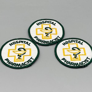May include: Three white and green embroidered patches with the text "Hospital Pharmacist" and a stylized image of a pharmacy cross with a snake wrapped around it.