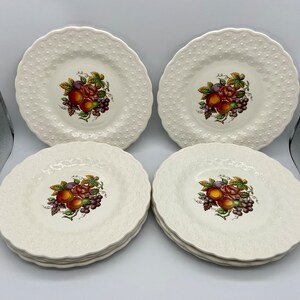 May include: Set of six white ceramic dessert plates with a raised embossed pattern. Each plate features a colorful fruit and floral design.
