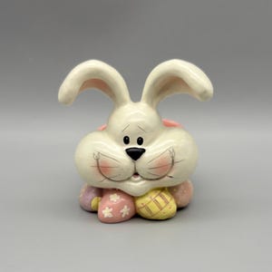 May include: A set of three ceramic mugs with a speckled, matte finish. The mugs are in shades of cream, light gray, and dark gray. Each mug has a simple, minimalist design, perfect for coffee or tea.