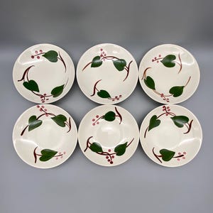 May include: Set of six white ceramic bowls with a green vine and pink berry design.