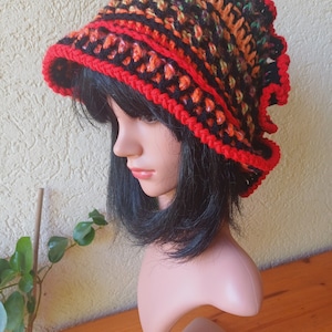 May include: A crocheted hat with a wide brim and a ruffled edge. The hat is made in a variety of colors, including black, orange, red, and green.
