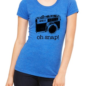 May include: A royal blue t-shirt with a black and white illustration of a vintage camera and the text "oh snap!"