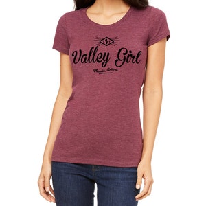 May include: A maroon heather t-shirt with a black graphic design that says "Valley Girl" with the text "Phoenix, Arizona" underneath.