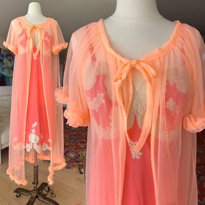 以下が含まれることがあります： レースのトリムが付いたピーチ色のシアーなナイトガウンと、それに合わせたローブ。ローブは首にリボンが付いており、軽量な生地で作られています。