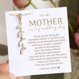 May include: A gold necklace with a leaf-shaped pendant, presented with a card inscribed with "TO MY MOTHER on my wedding day." The card contains a message of appreciation and love.