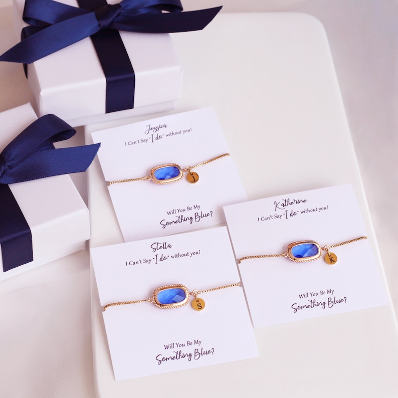 May include: Three white cards with blue and gold bracelets and personalized messages. The cards read "I Can't Say 'I do' without you!" and "Will You Be My Something Blue?"